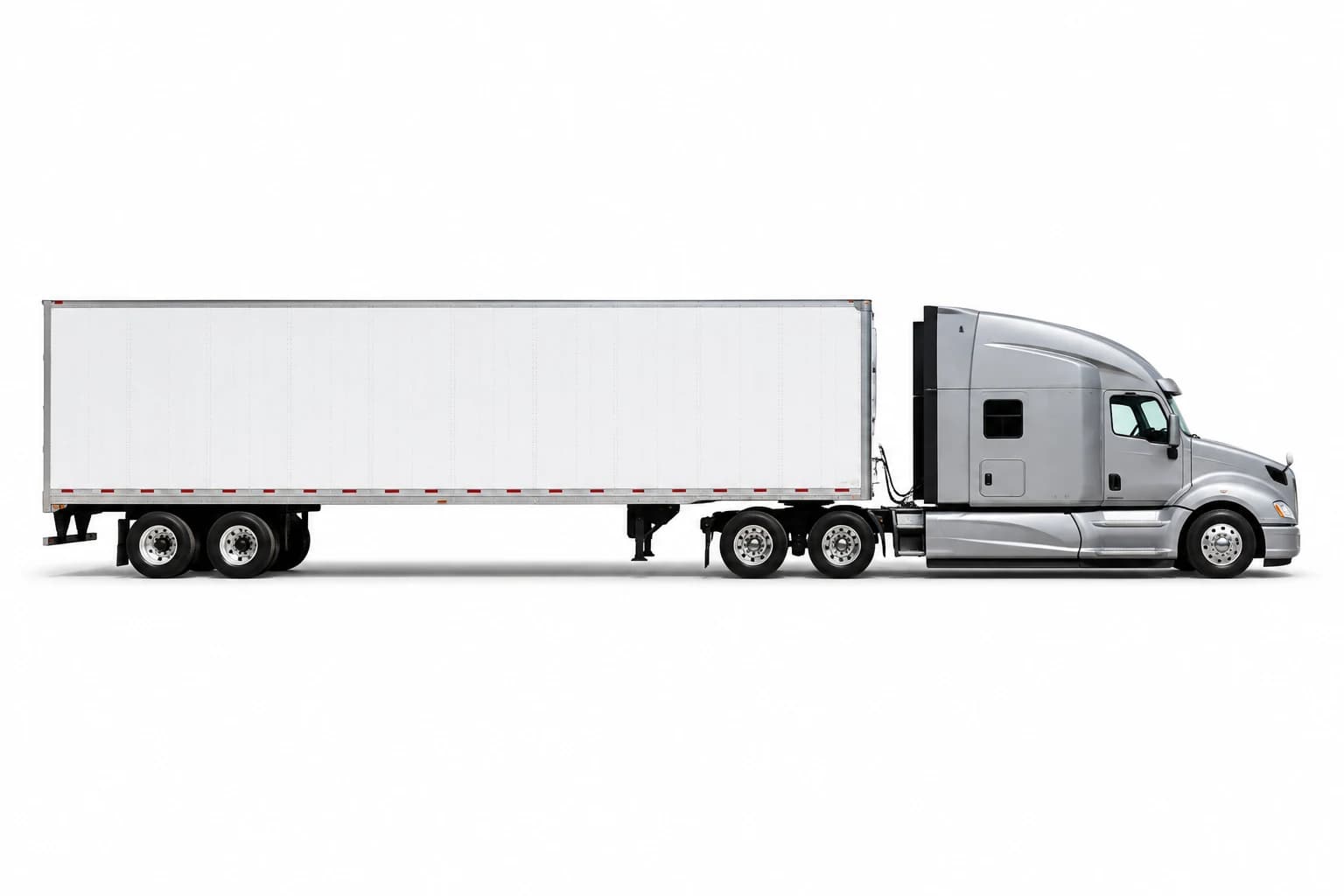 Side view of a silver semi truck and white dry van trailer